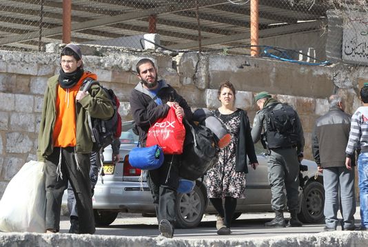 Des colons israéliens sont expulsés des logements dont ils avaient pris possession, le 22 janvier 2016 à Hébron. HAZEM BADER / AFP