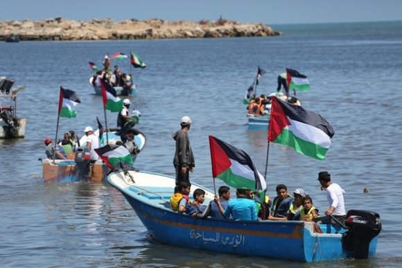 Dans le port de Gaza, des protestataires palestiniens sont montés à bord de bateaux, dans le cadre des événements marquant les dix années du siège de l'enclave (MEE/Mohammed Asad)