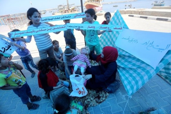 Au port de Gaza, un groupe d'enfants réclament des médicaments, le droit de se déplacer et la fin du siège (MEE/Mohammed Asad)