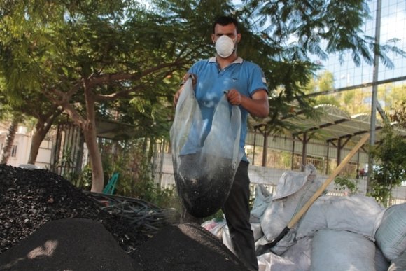 Un homme tient un sac de cendre de charbon (photo fournie par Majd Mashhrawi)