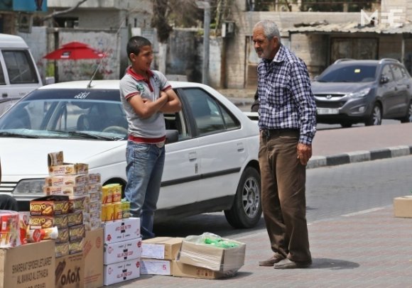 Un enfant vend des biscuits sur un trottoir (MEE/Mohammed Asad)