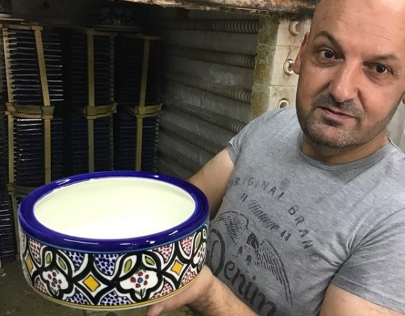 Emad Natsheh montre un plat en céramique qui a refroidi dans le four (MEE/Katie Miranda)