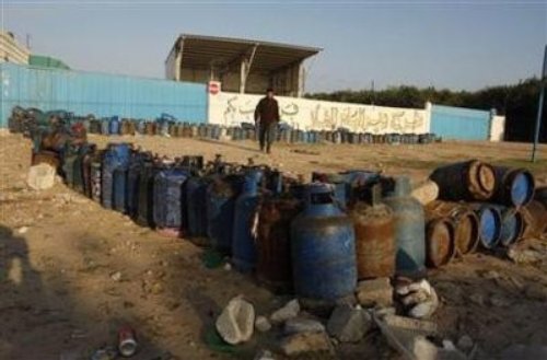 Un Palestinien déambule au milieu de bombonnes de gaz vides alignées le long d'une station de distribution dans le sud de la bande de Gaza.