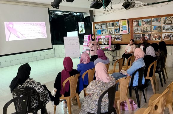 Atelier de sensibilisation pour les femmes sur le cancer du sein intitulé "Votre santé nous intéresse" en présence d'un groupe de femmes dans le camp Aïda