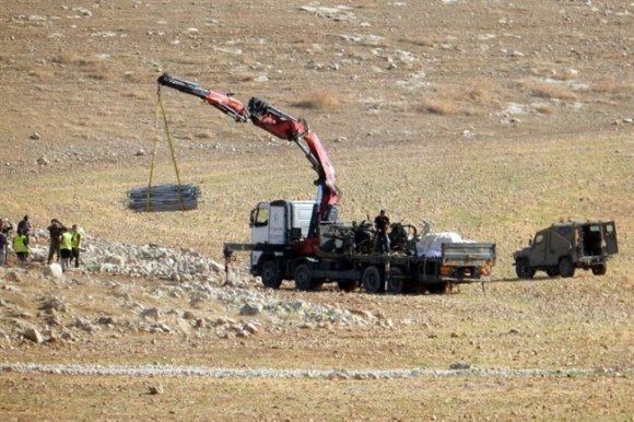 Le personnel de l'Administration Civile (en fait une administration militaire qui n'a de civile que le nom) en train de charger des parties de tentes sur un camion à plateau. Photo d'un bénévole de B'Tselem, 30 novembre 2015.