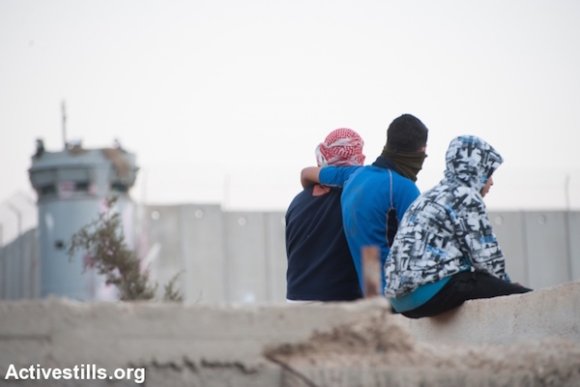 Des jeunes du Camp de Réfugiés d'Aïda se reposent pendant une accalmie dans les affrontements avec les forces israéliennes près du Mur de Séparation dans la ville de Bethléem en Cisjordanie, le 16 novembre 2013. (Activestills.org)