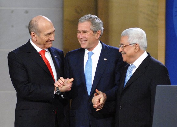 Le Premier Ministre israélien Ehud Olmert, le Président George W. Bush et le Président Palestinien Mahmoud Abbas se serrent la main à la Conférence d'Annapolis dans la Salle du Souvenir de l'Académie de la Marine à Annapolis, Maryland, le 27 novembre 2007. (Gin Kai/U.S. Navy)